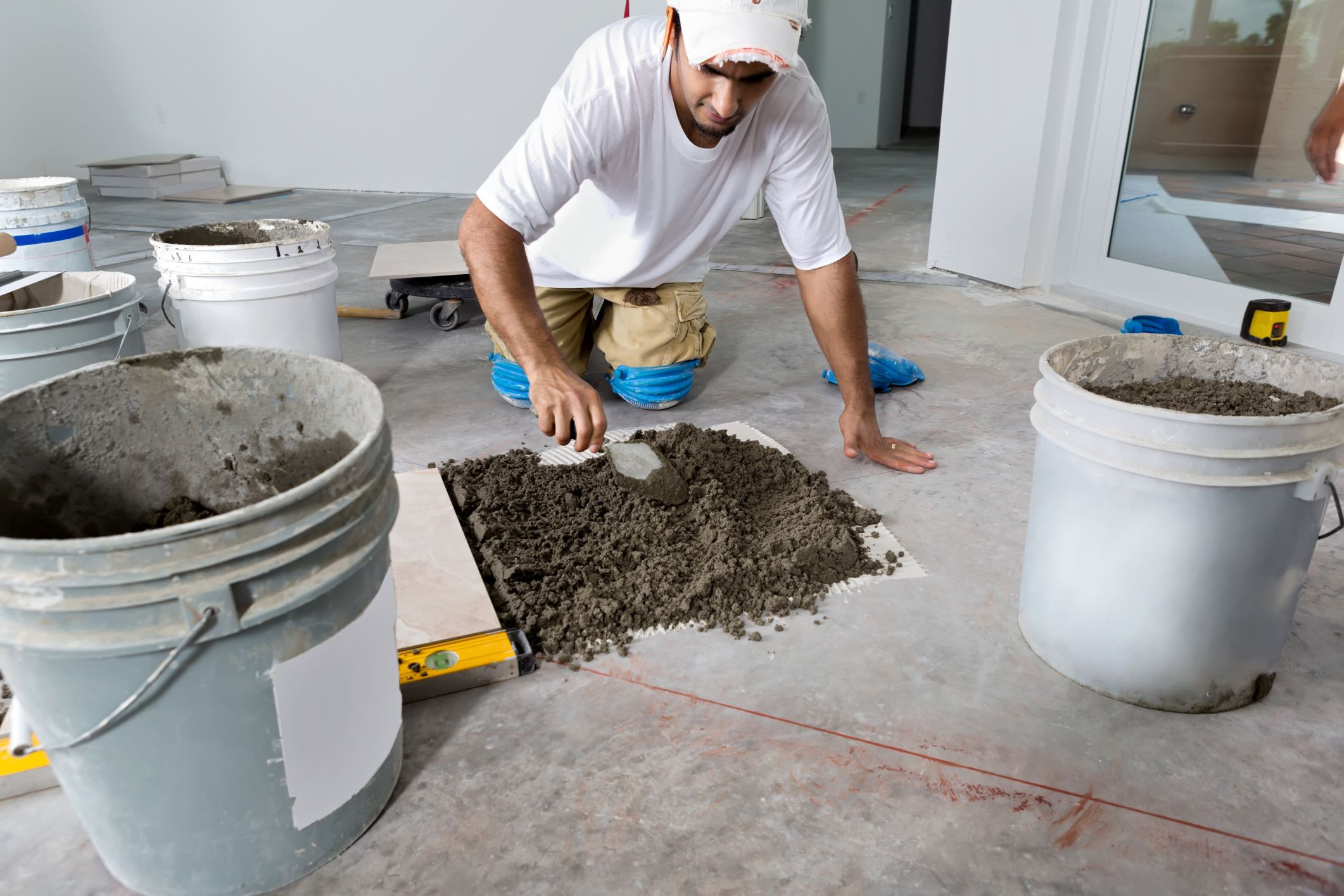 hardwood floor repair portland oregon of can you install tile over concrete inside man laying tile floor 155601792 56a49ef75f9b58b7d0d7e06d